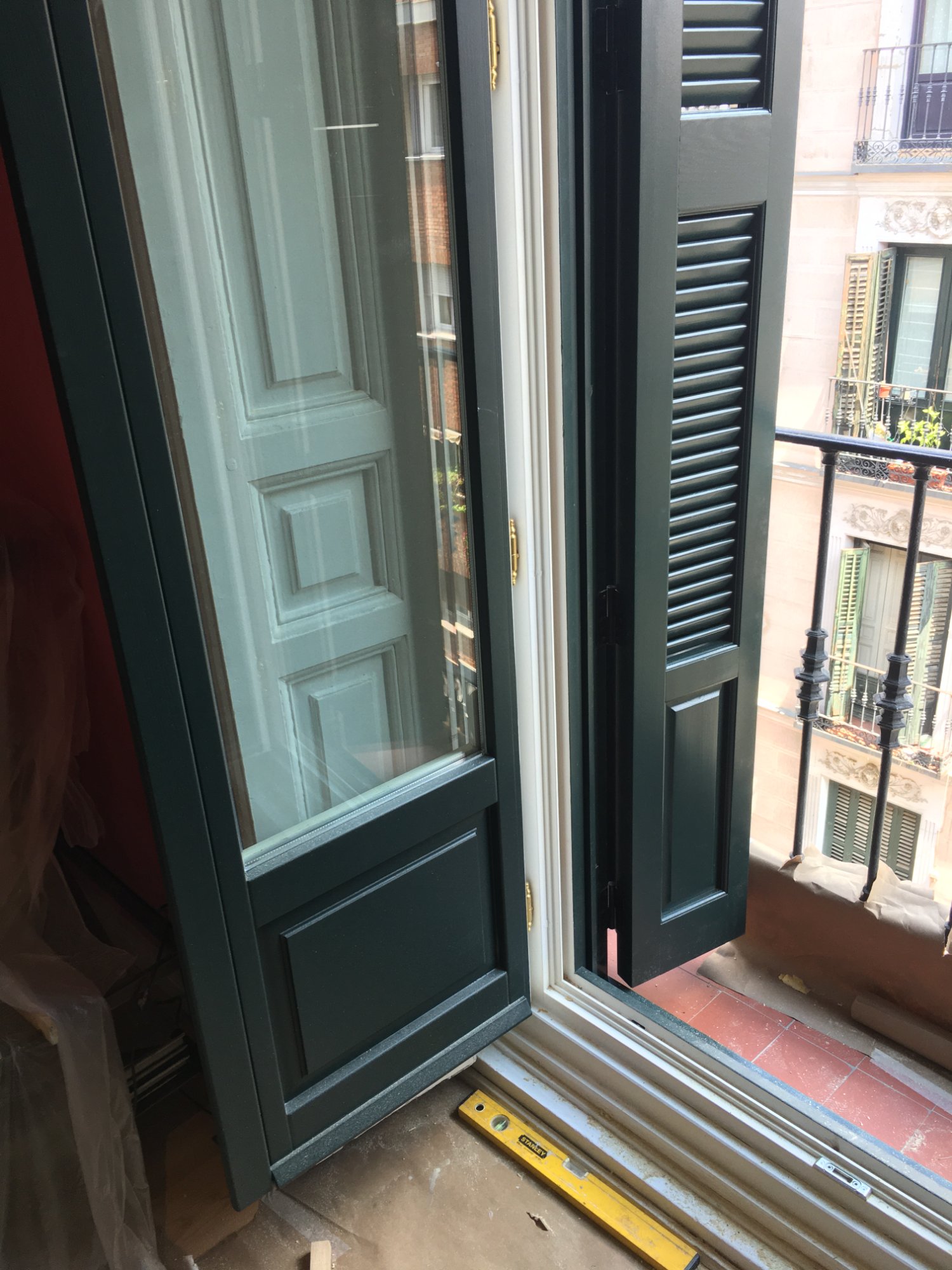 Puerta balconera de madera verde aislamiento acústico edificio protegido Madrid
